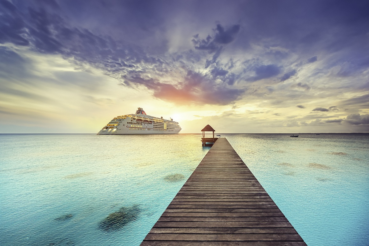 Beautiful Polynesian sunset over the clear waters of the South Pacific. Silhouettes of people standing on Jetty. Fakarava, French Polynesia.