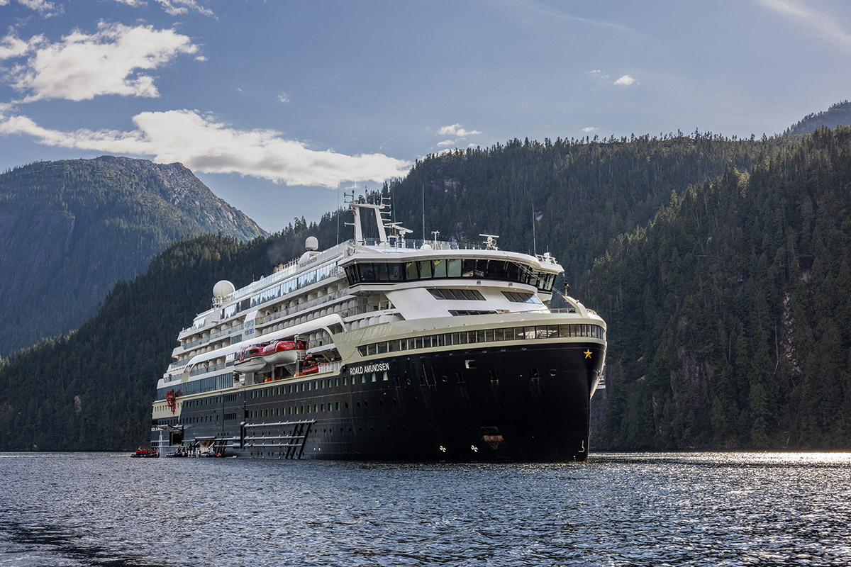 Die MS Roald Amundsen von HX Expeditions fährt durch eine beeindruckende Naturlandschaft. Das Hybrid-Expeditionsschiff gleitet ruhig durch das weite Gewässer.